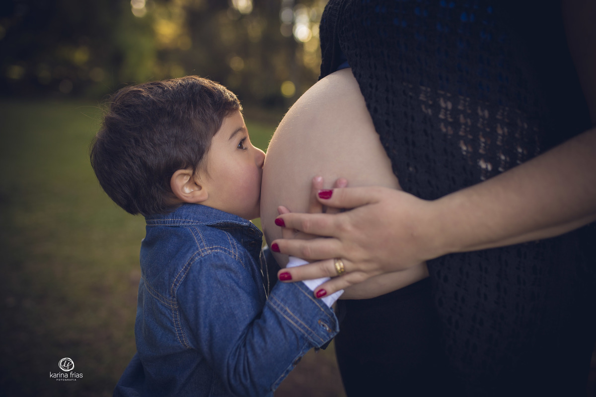 o filho mais novo beija a barriga da mae