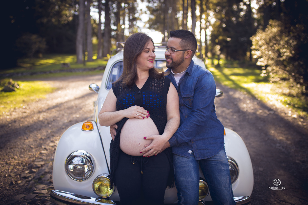 os pais estao apoiados no fusca da familia