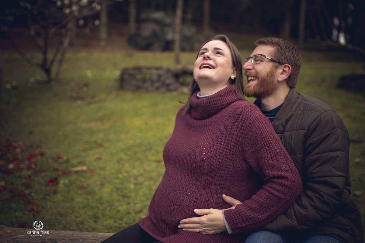 os pais sorriem enquanto a fotografa de familia de caxias do sul-rs, karina frias, registra o momento