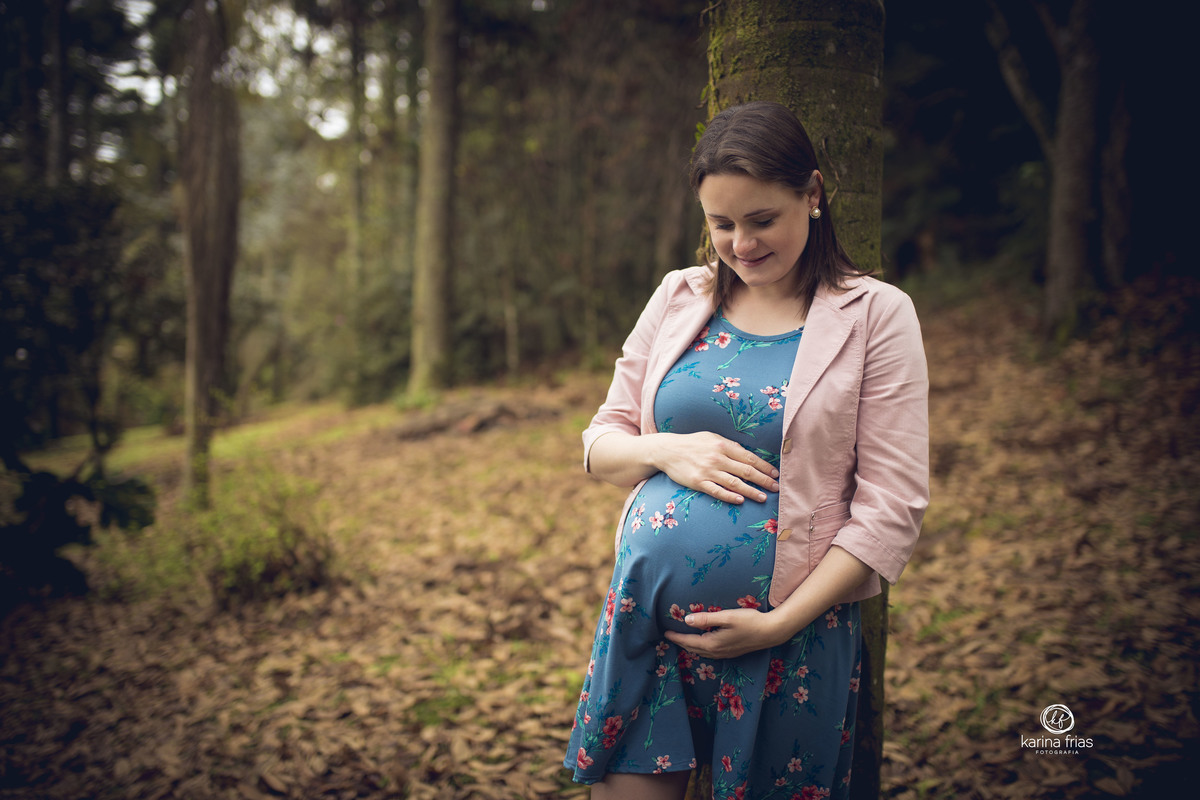 no ensaio de gestante externo, a mamae olha para a barriga