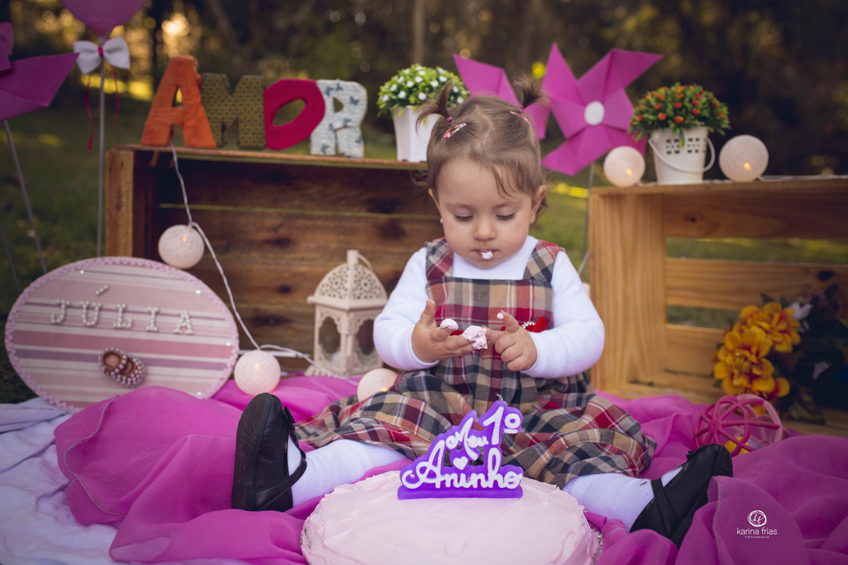 a bebe olha para o glace do bolo no ensaio smash the cake