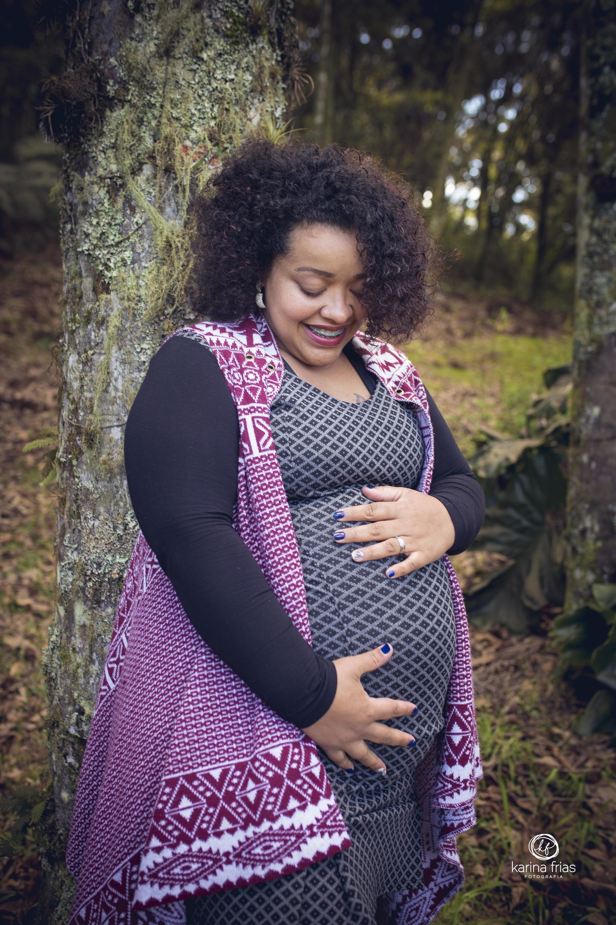 a gestante olha a barriga enquanto a fotografa de familia de caxias do sul-rs registra o momento
