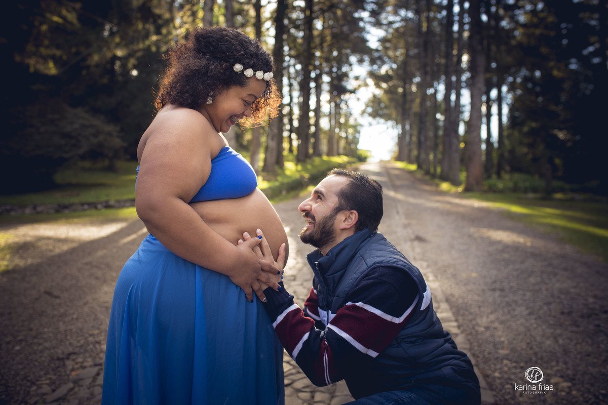o pai sorri para a gestante nas fotos externas