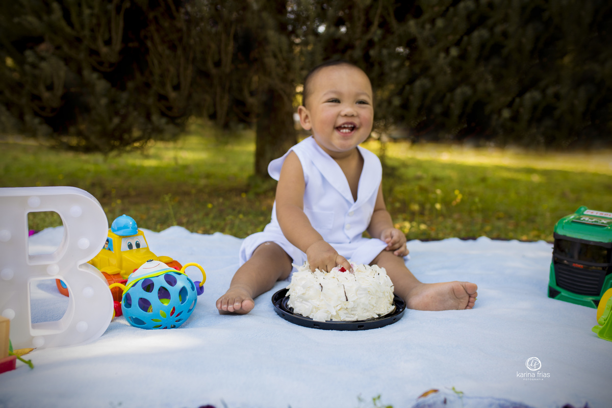a criança sorri durante ensaio smash the cake