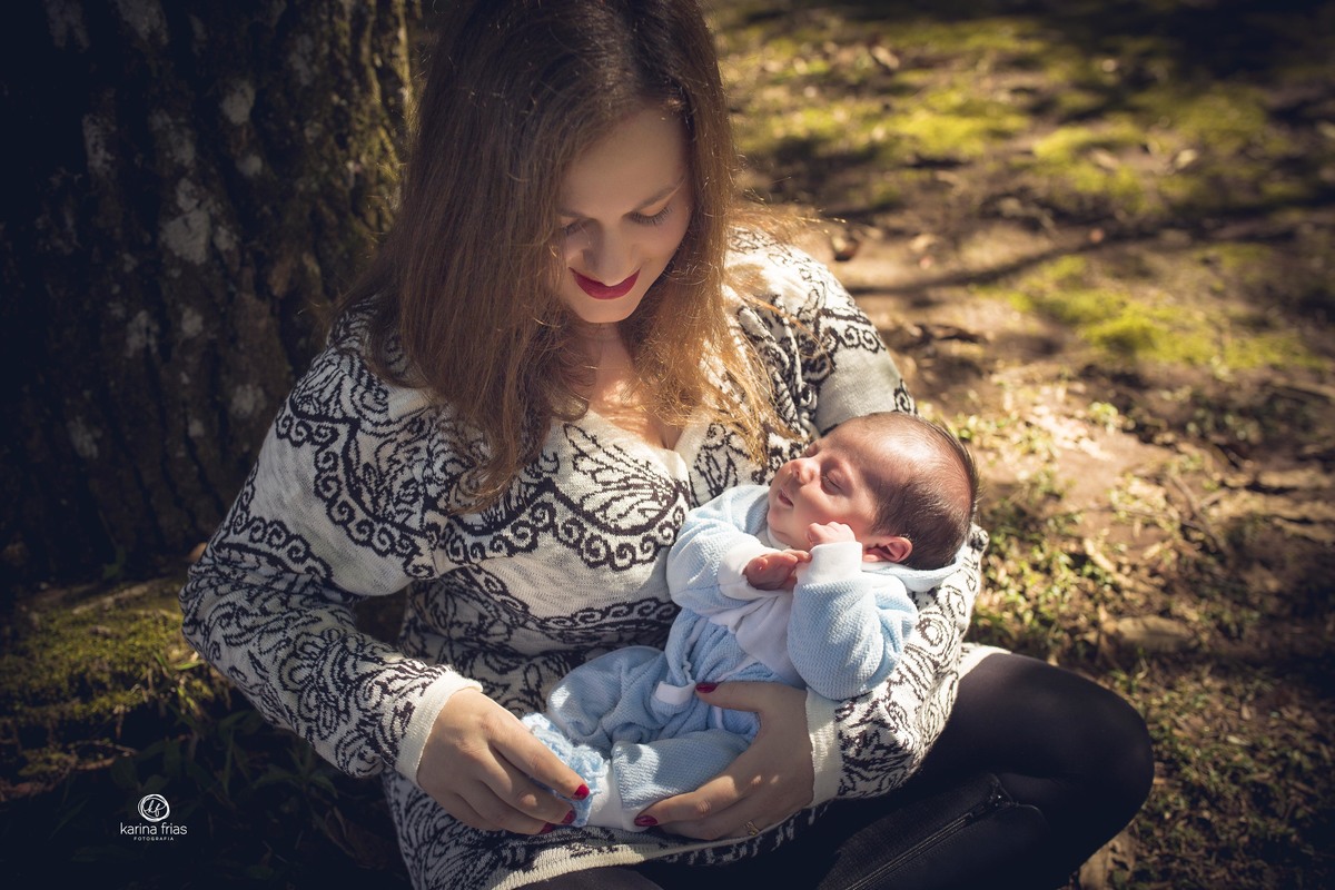 A MAE ESTA SEGURANDO O FILHO NO COLO DURANTE ENSAIO DE FAMILIA