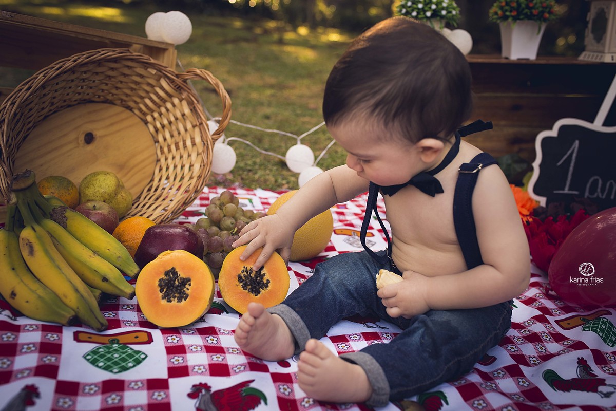 A CRIANÇA BRINCA COM AS FRUTAS NO ENSAIO INFANTIL