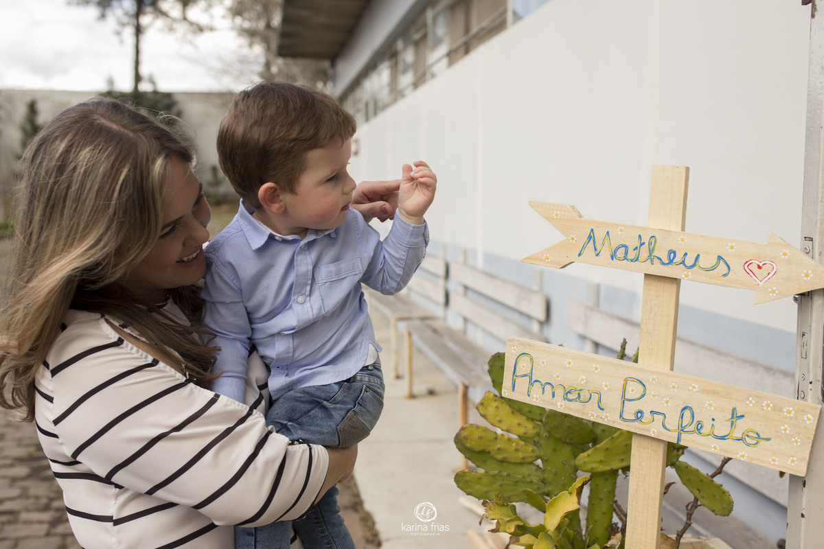 A MAE MOSTRA AS PLACAS PARA O FILHO NO ENSAIO INFANTIL