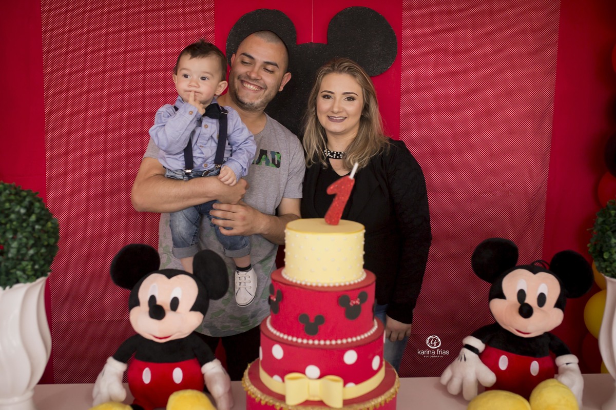 OS PAIS POSAM NA MESA DE ANIVERSARIO COM O FILHO