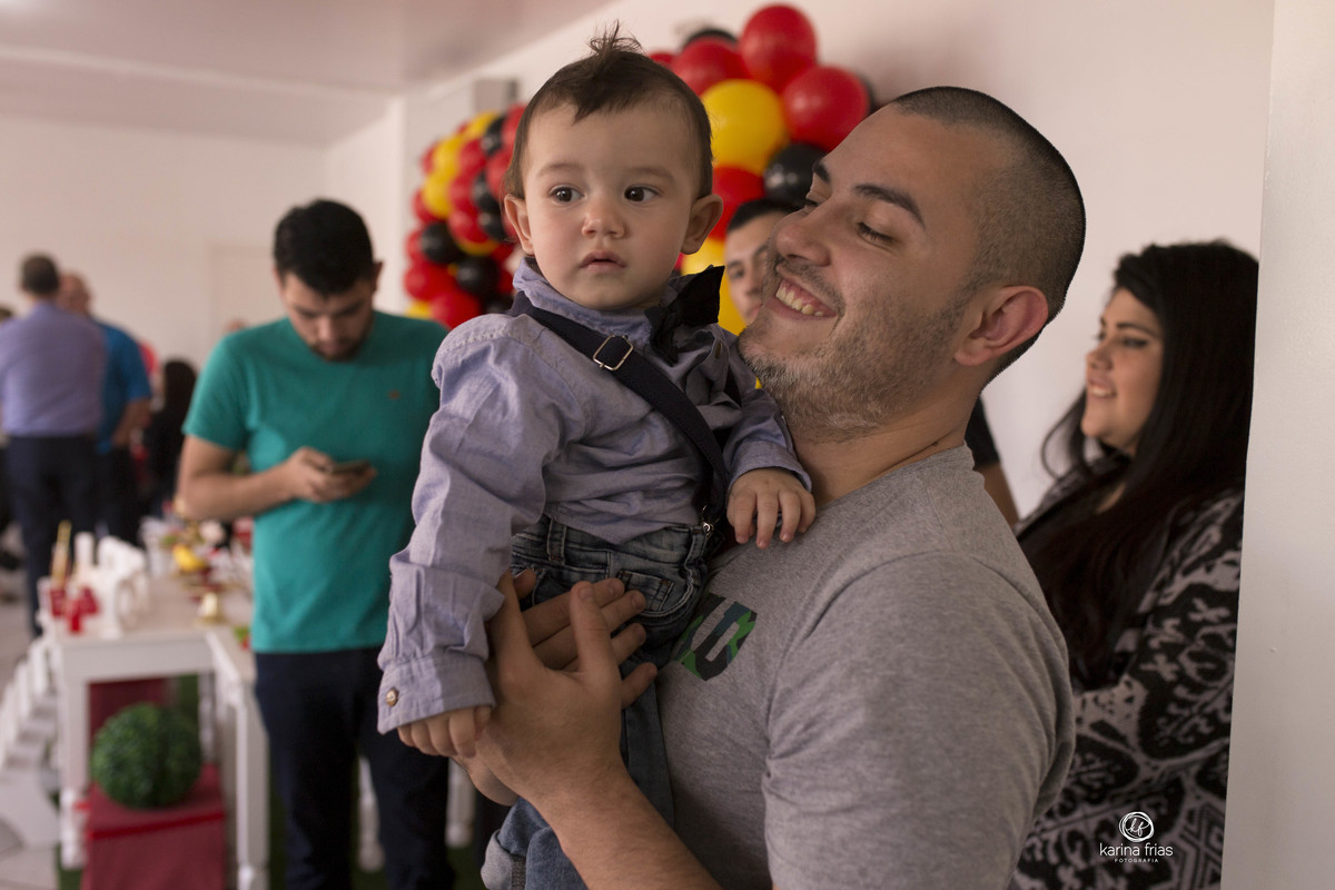O BEBE ESTA NO COLO DO PAI NA FESTA DE ANIVER