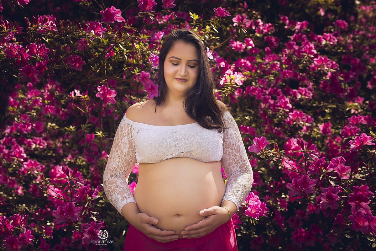 A GESTANTE ESTA EM MEIO AS FLORES NO SEU ENSAIO EXTERNO