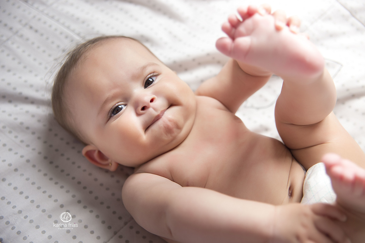 A BEBE SEGURA O PÉ PARA AS FOTOS MENSAIS