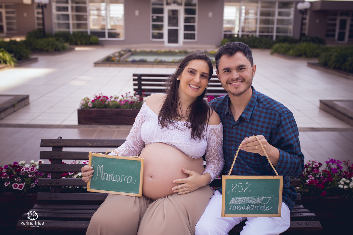 os pais seguram as plaquinhas para a espera da filha