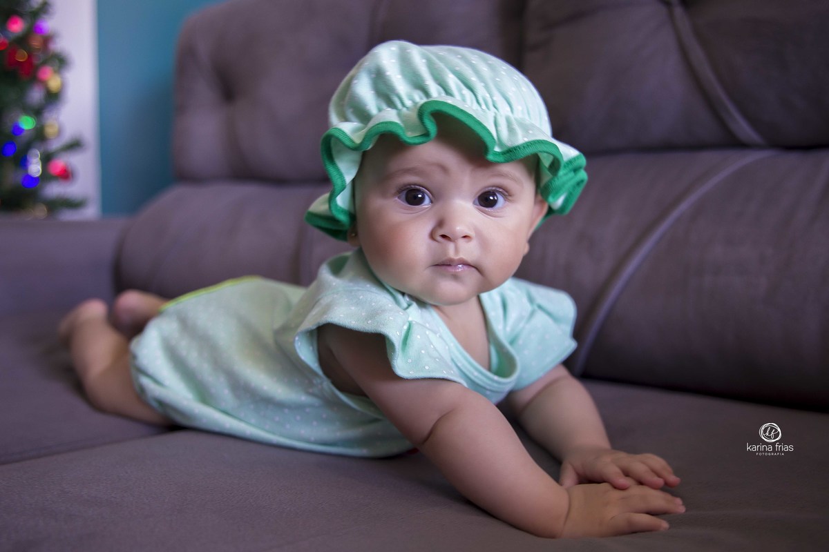 no ensaio infantil a bebe esta de bruços no sofá