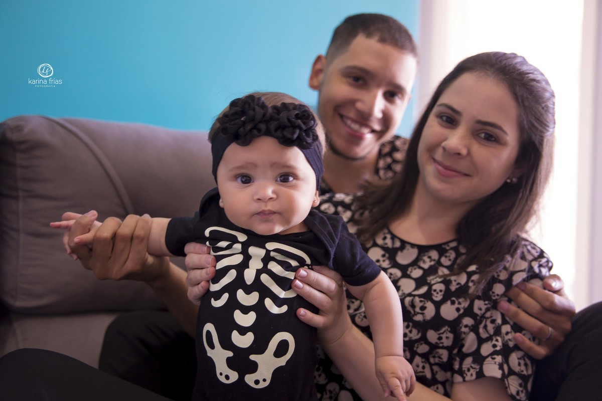 a familia esta sentada no sofa para as fotos em casa