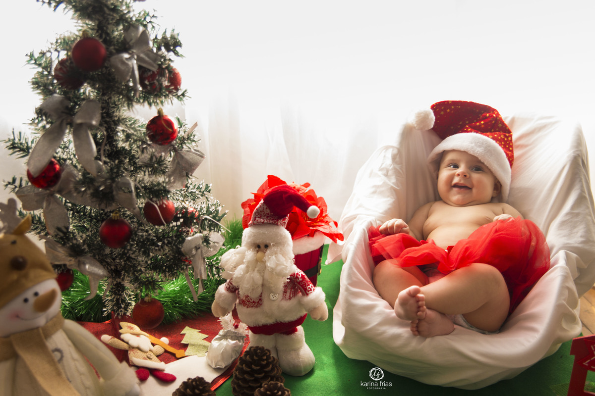 a bebe sorri no ensaio de natal em casa