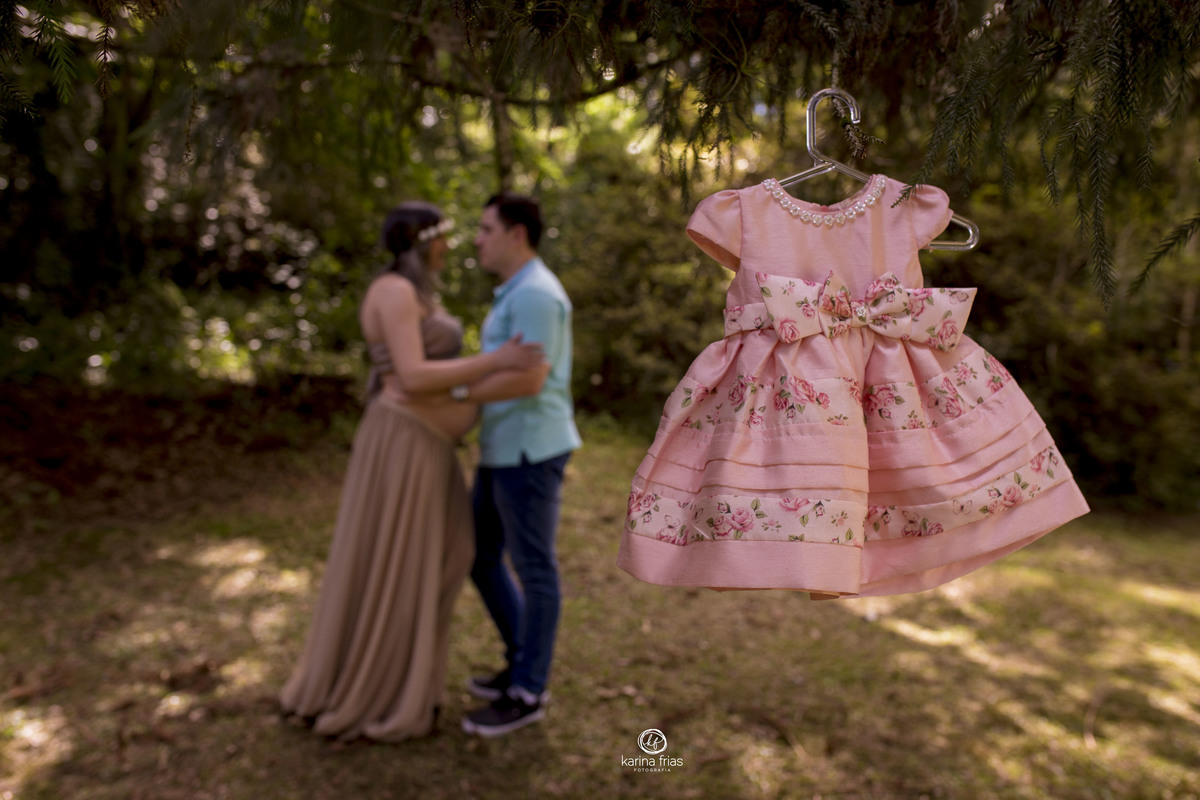 O VESTIDO ESTA NA FRENTE E OS PAIS DESFOCADOS AO FUNDO