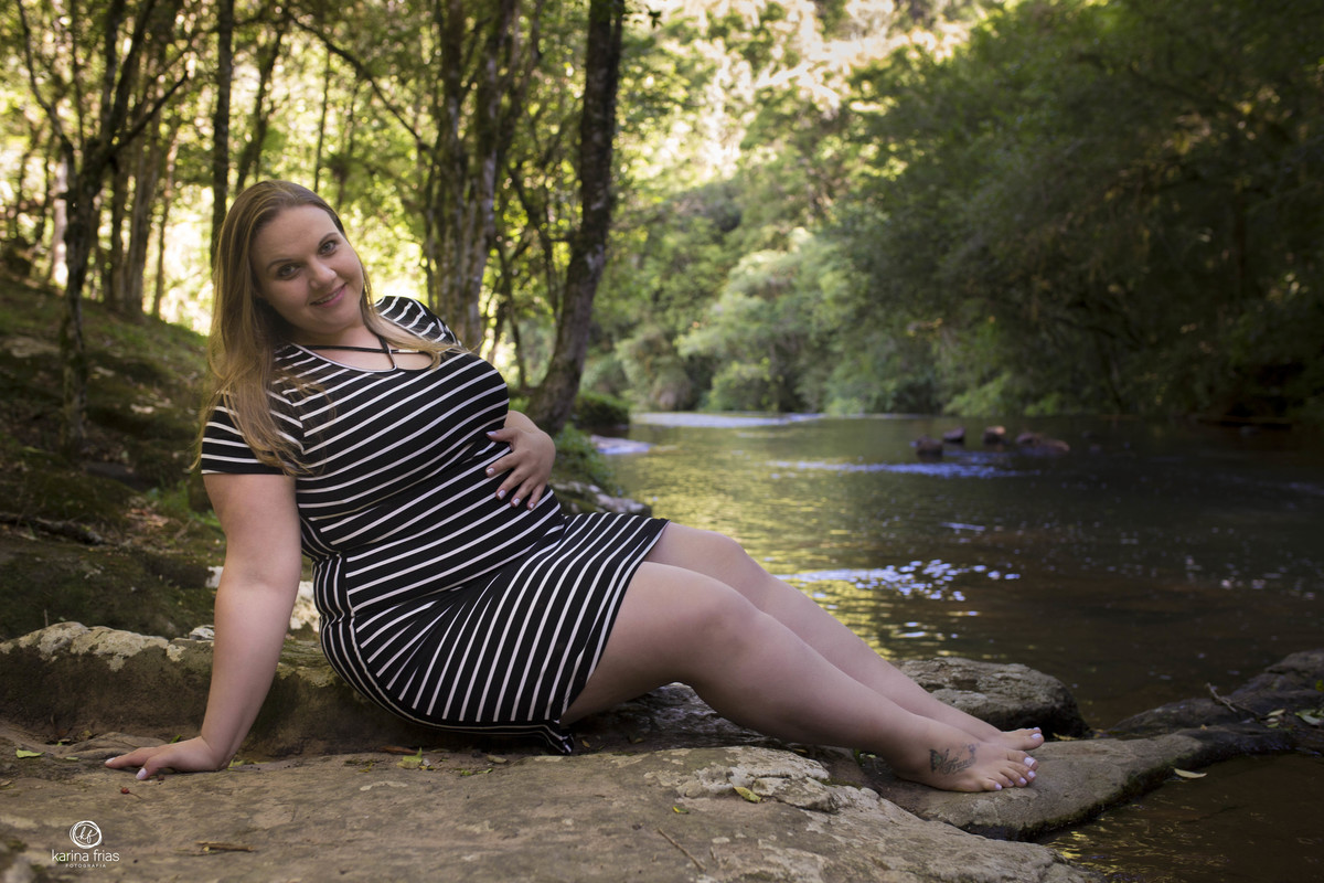a gestante esta sentada perto do rio