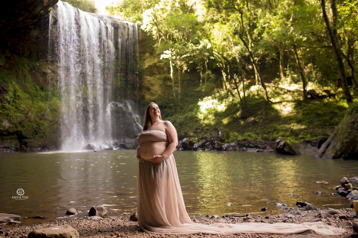 a gestante sente o sol e a cachoeira esta ao fundo