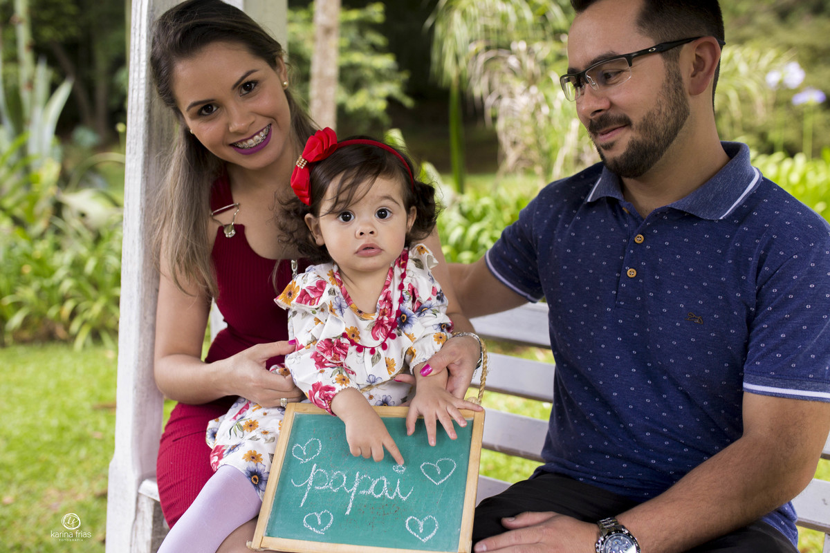 a bebe segura a placa para as fotos de familia