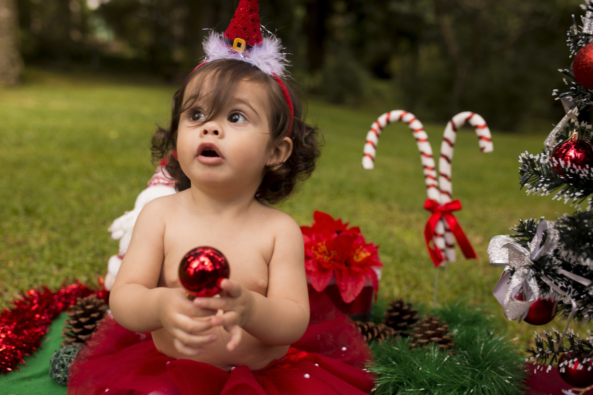 a bebe esta segurando a bolinha de nata para as fotos