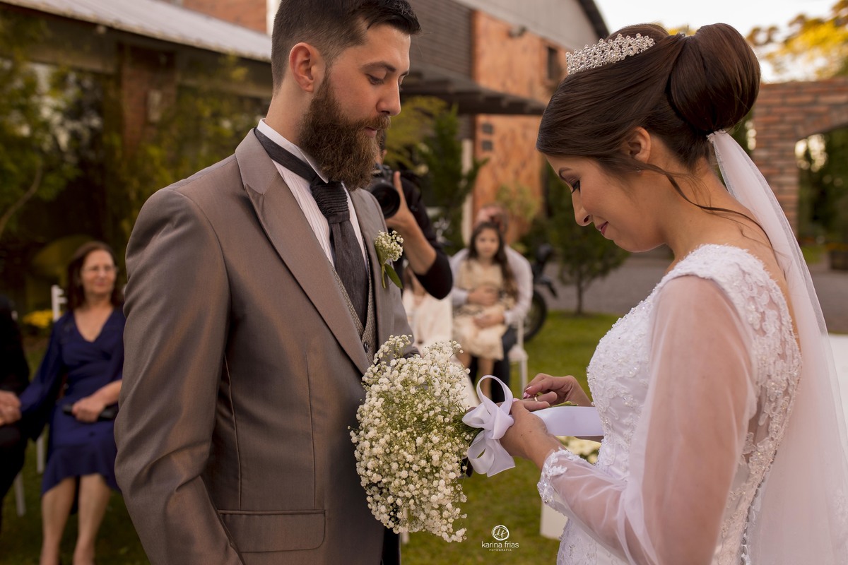 a noiva coloca a aliança no noivo