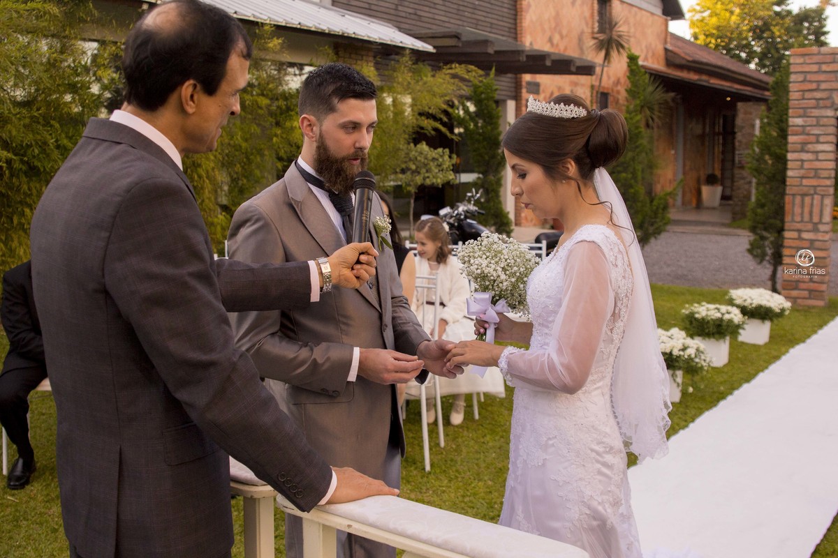 o noivo coloca a aliança na noiva