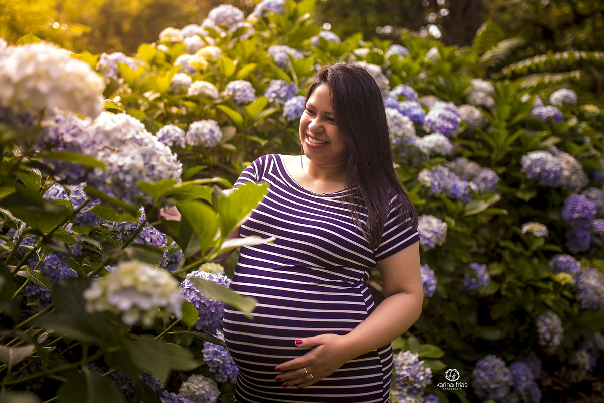 a gestante mexe nas flores no ensaio