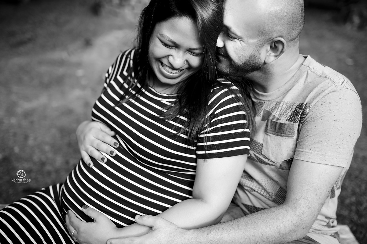 a gestante sorri para o pai no ensaio da espera do filho