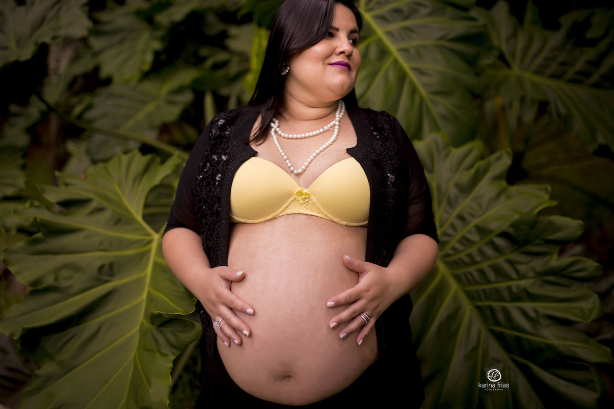 a gestante segura a barriga para as fotos de seu book externo