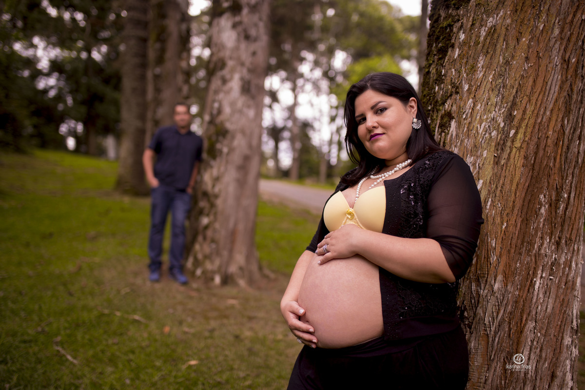 o pai esta desfocado ao fundo no ensaio de gestante