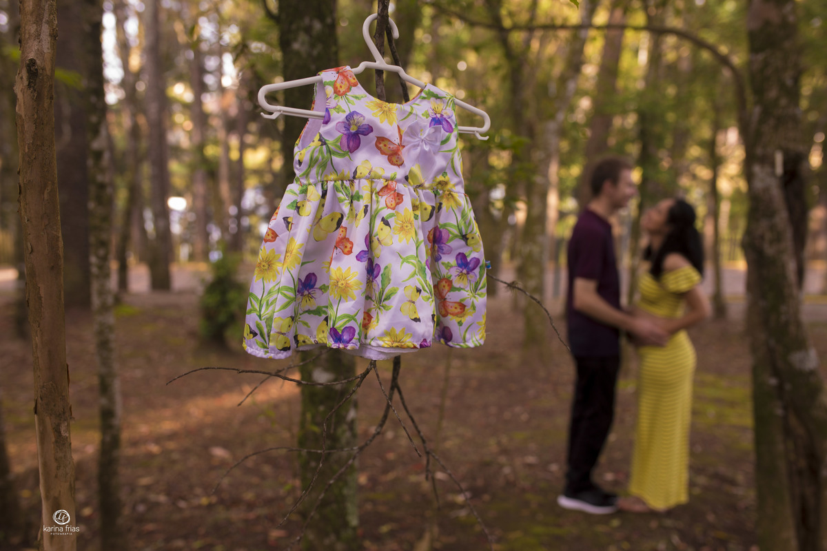 os pais estao desfocados ao fundo para as fotos de gestante