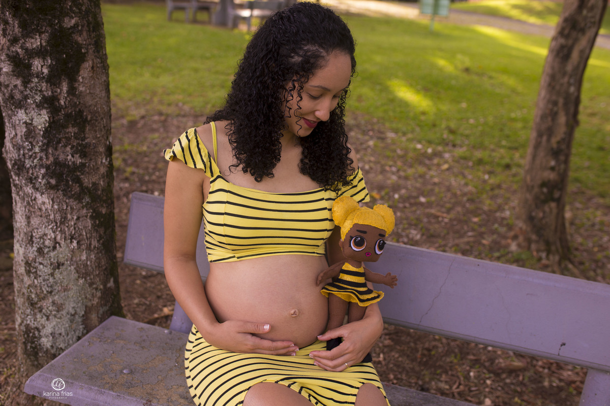 a gestante segura a boneca da filha no colo