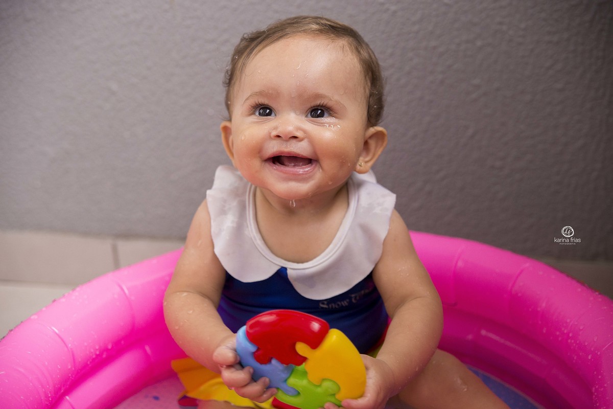 a bebe brinca na agua para as fotos do acompanhamento