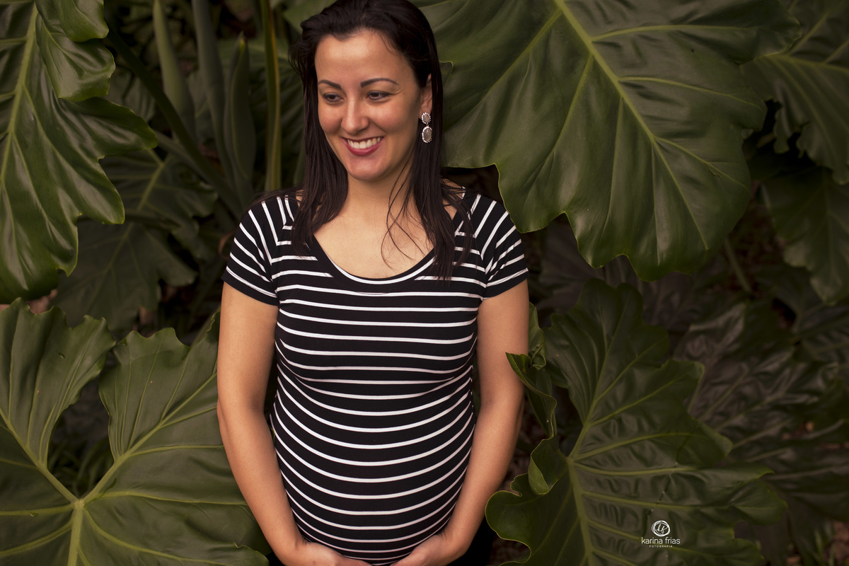 a gestante segura a barriga nas fotos externas
