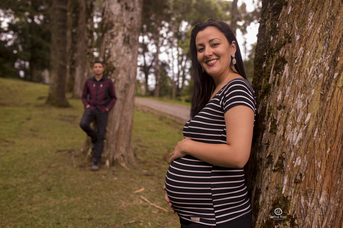 o pai esta desfocado ao fundo no ensaio de gestante