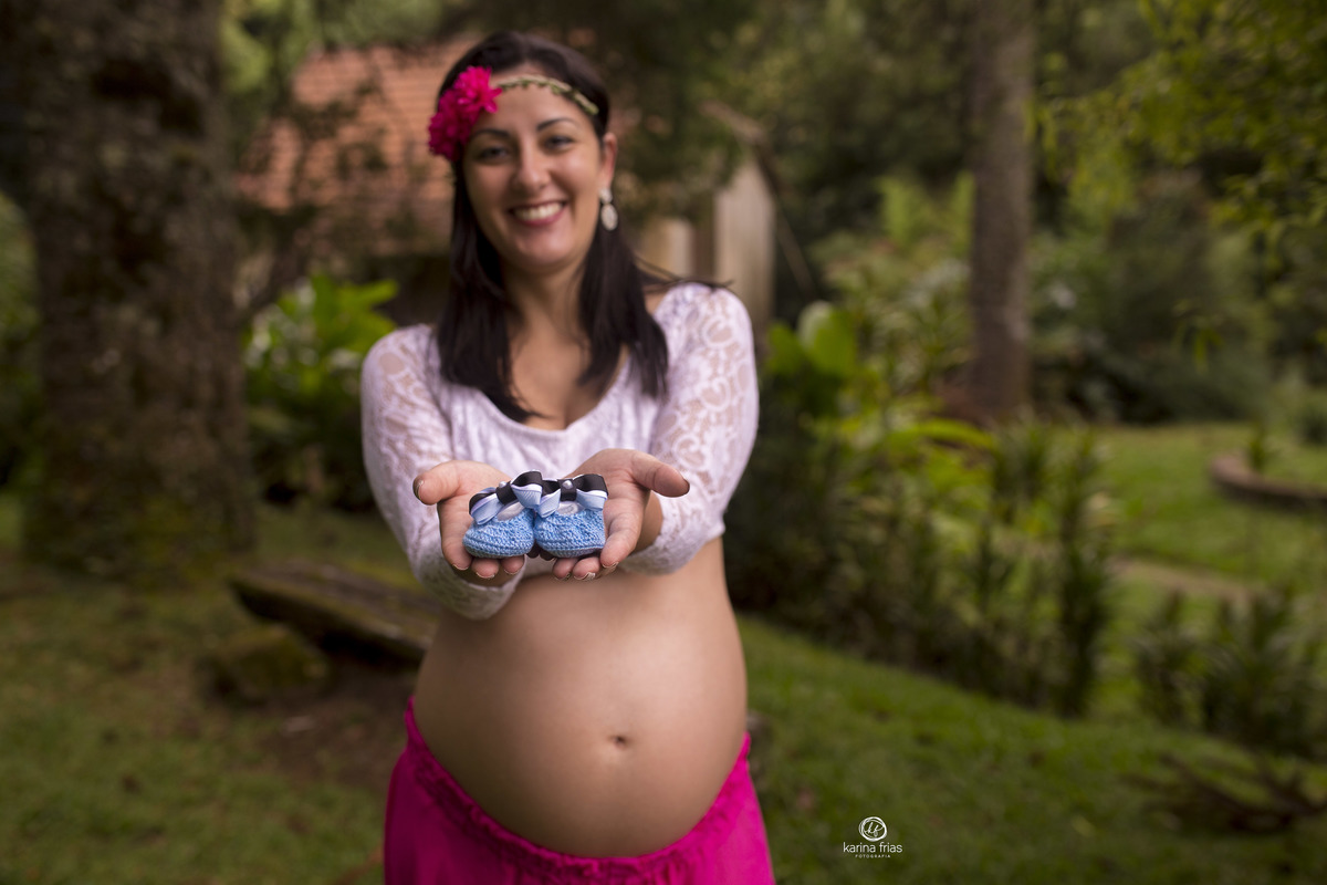 no ensaio externo de gestante, a modelo mostra o sapato da ebbe