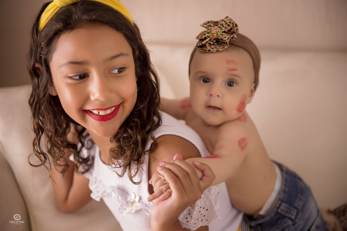a bebe brinca com a prima nas fotos do acompanhamento mensal