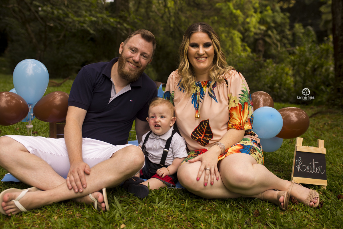 a familia esta sentada no cenario de ensaio smash the cake