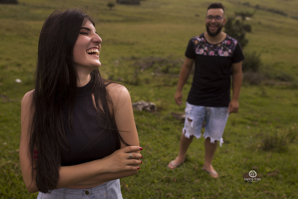 a moça sorri e o rapaz fica ao fundo