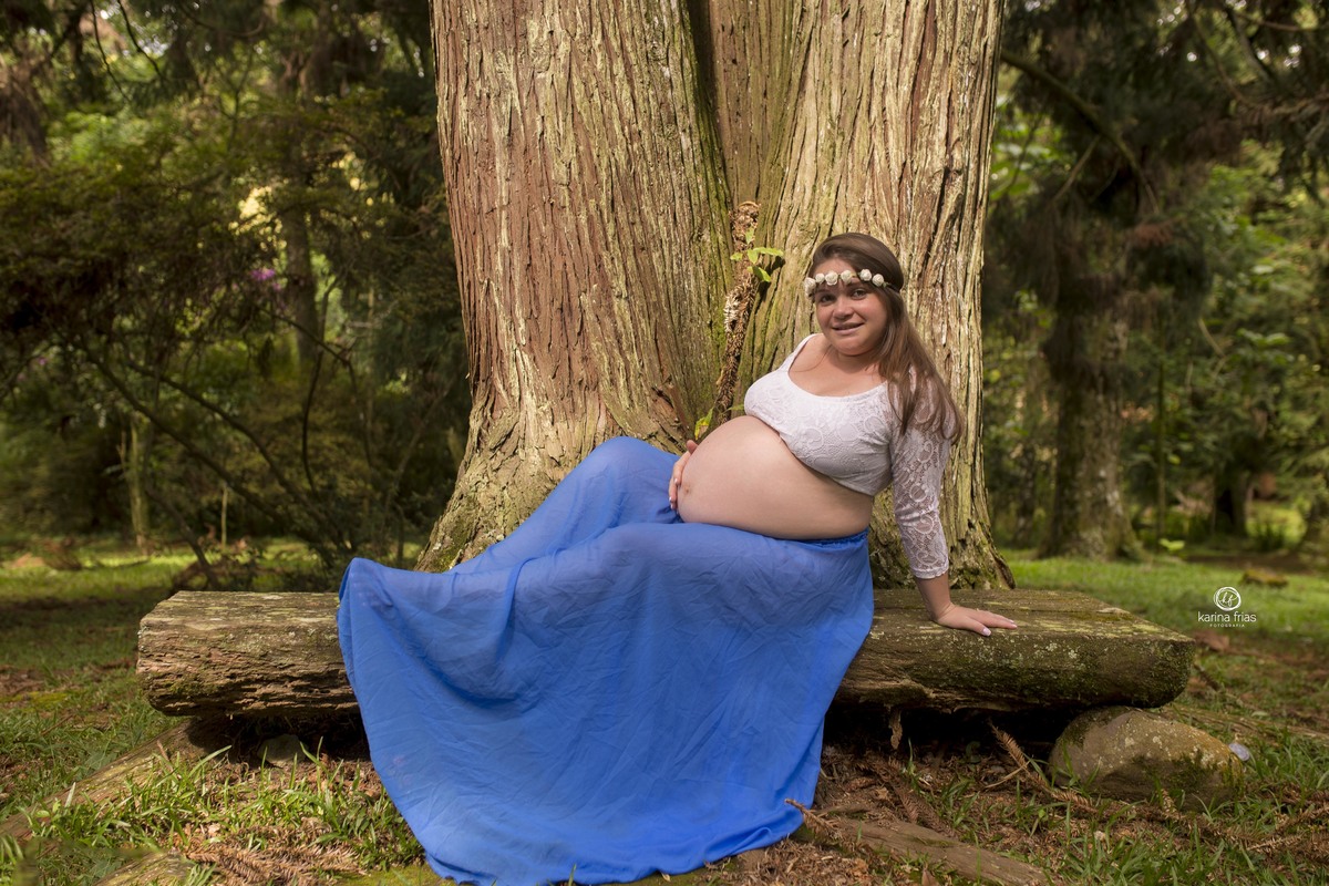 a modelo esta sentada mostrando a barriga