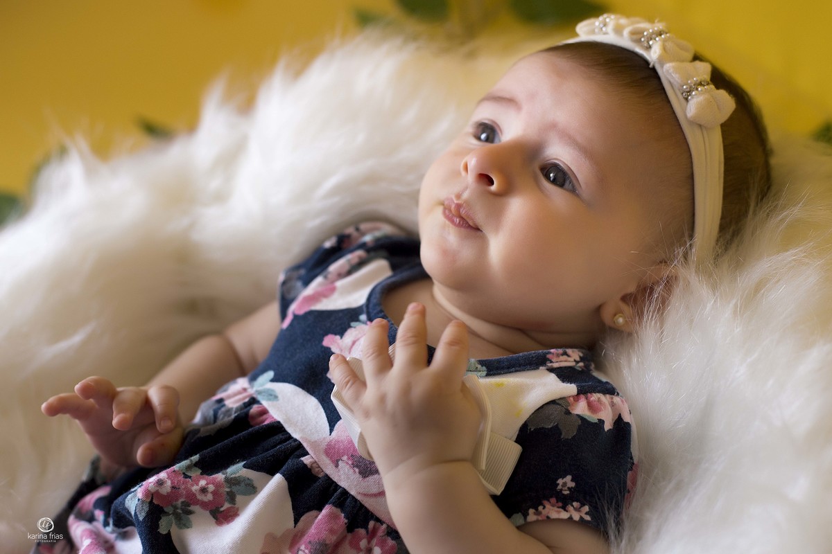 a bebe esta deitada no cesto olhando para os pais