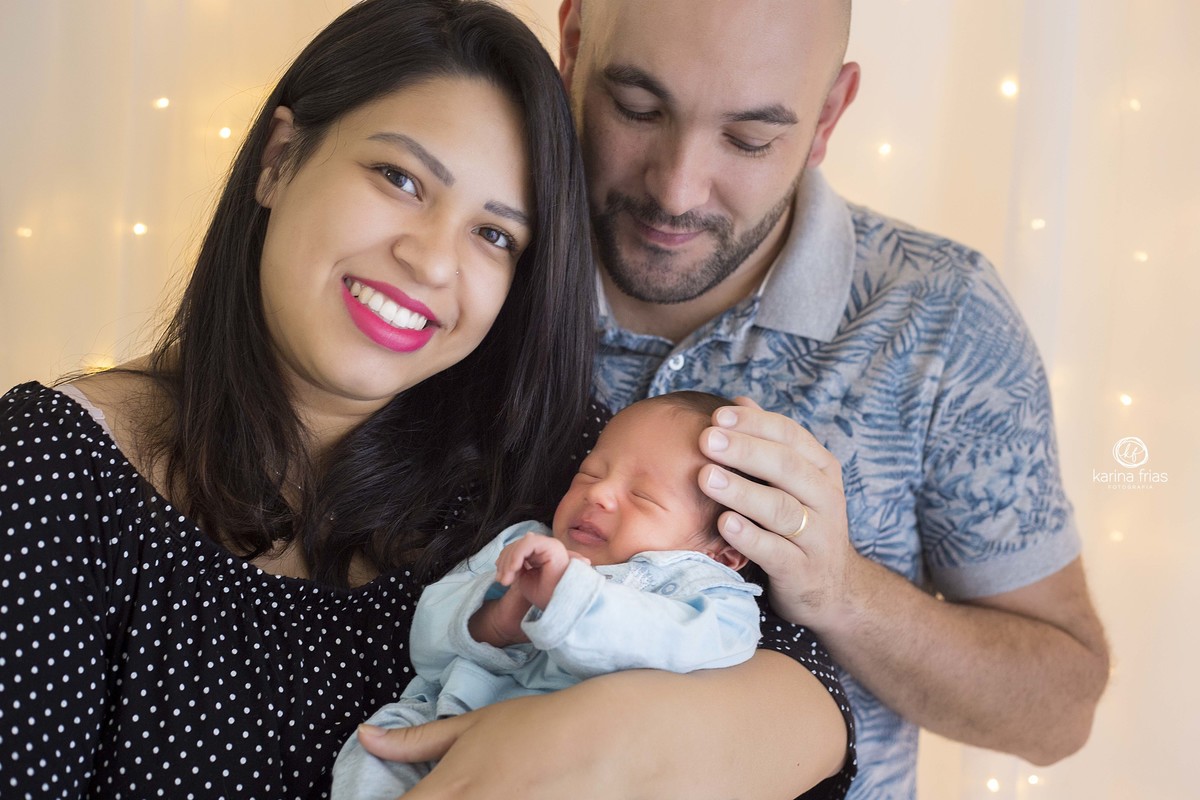 os pais seguram o bebe para o ensaio infantil