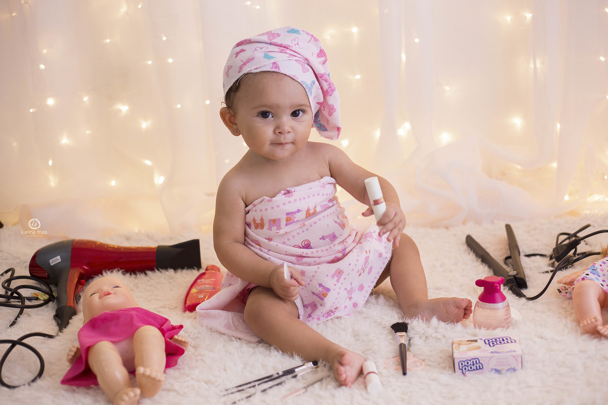 a menina brinca com as maquiagens durante ensaio
