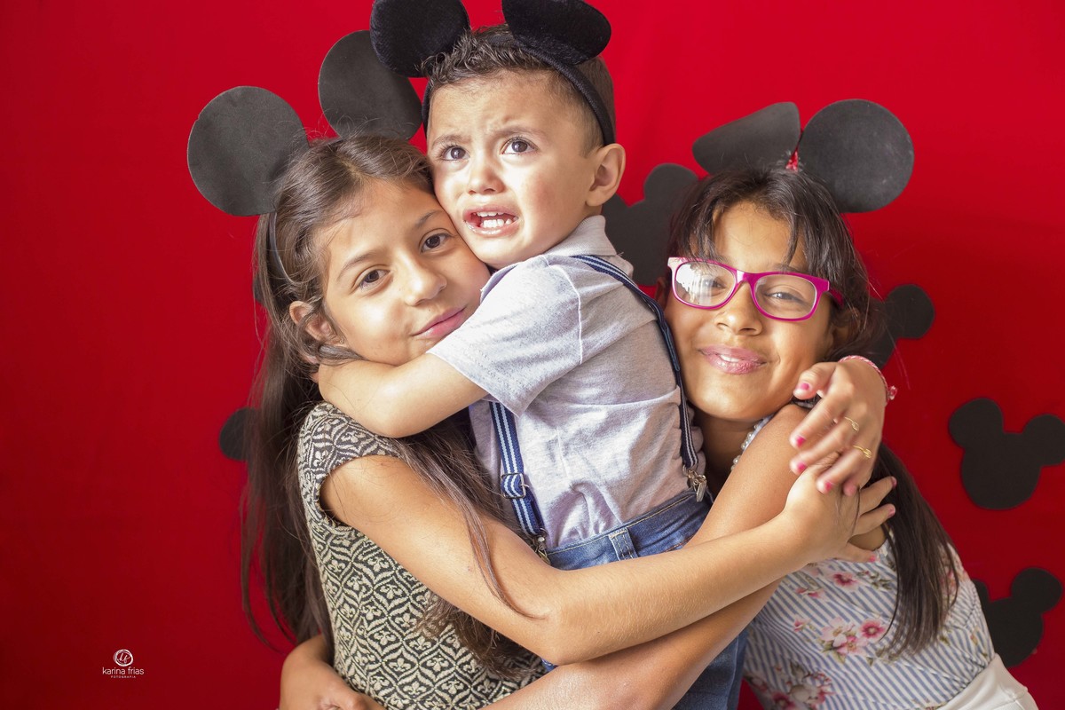 o menino é braçado pelas primas enquanto chora