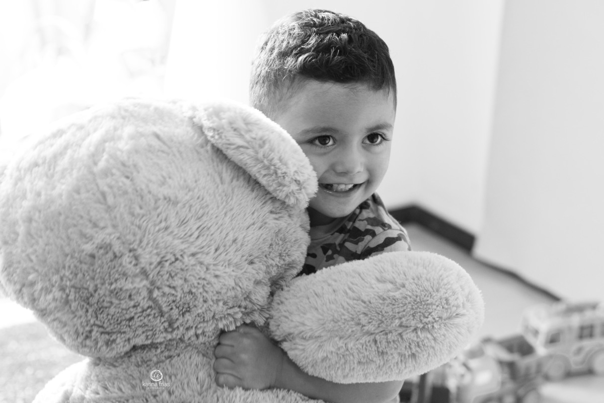o menino abraça o urso durante sessão de fotos