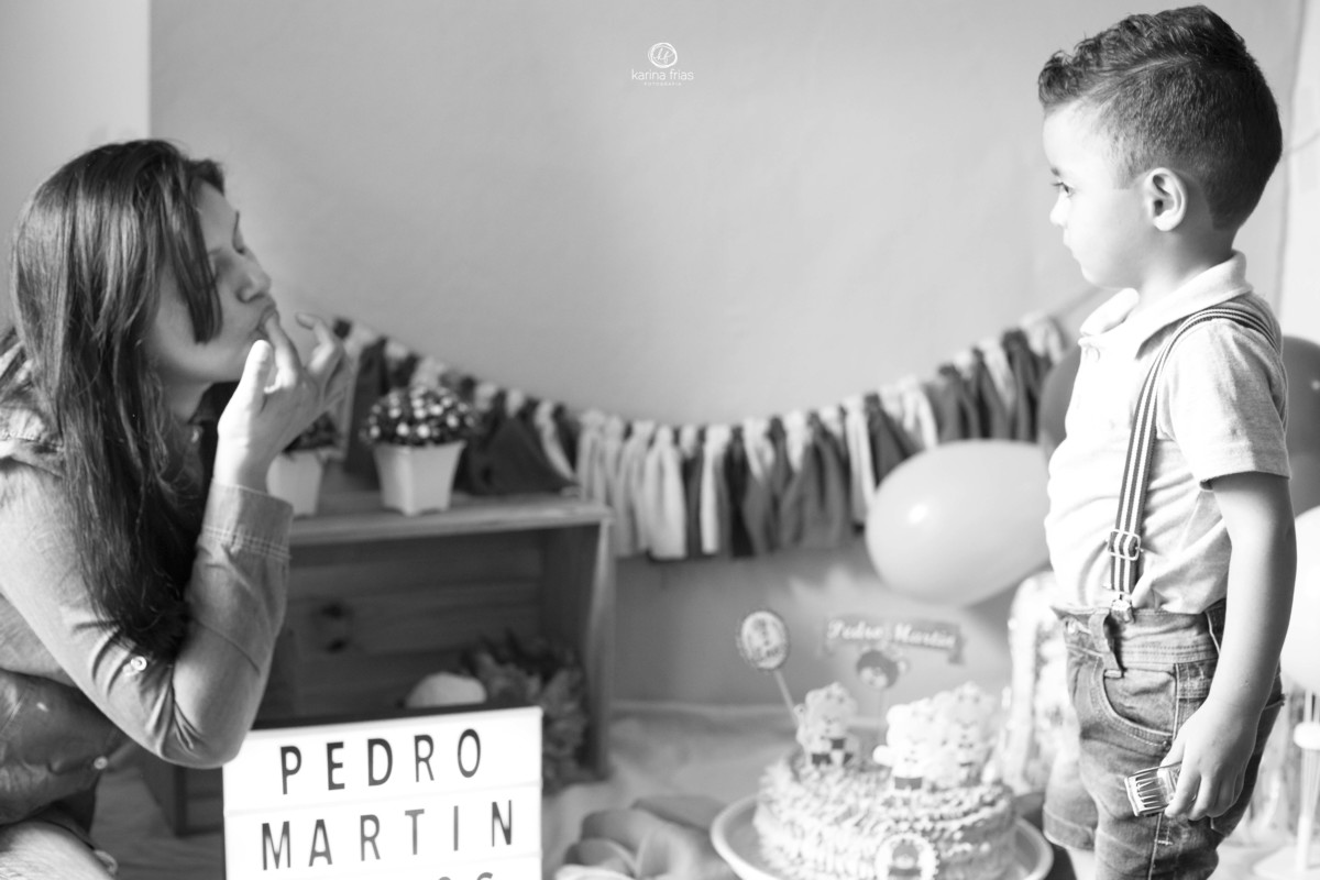 a mãe faz bico para o filho enquanto clicamos a sessão de fotos