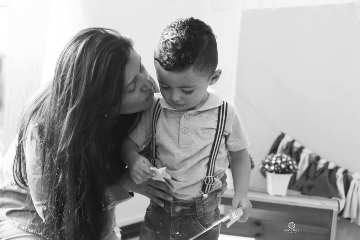 a mae beija o filho que esta inquieto durante a sessão fotografica
