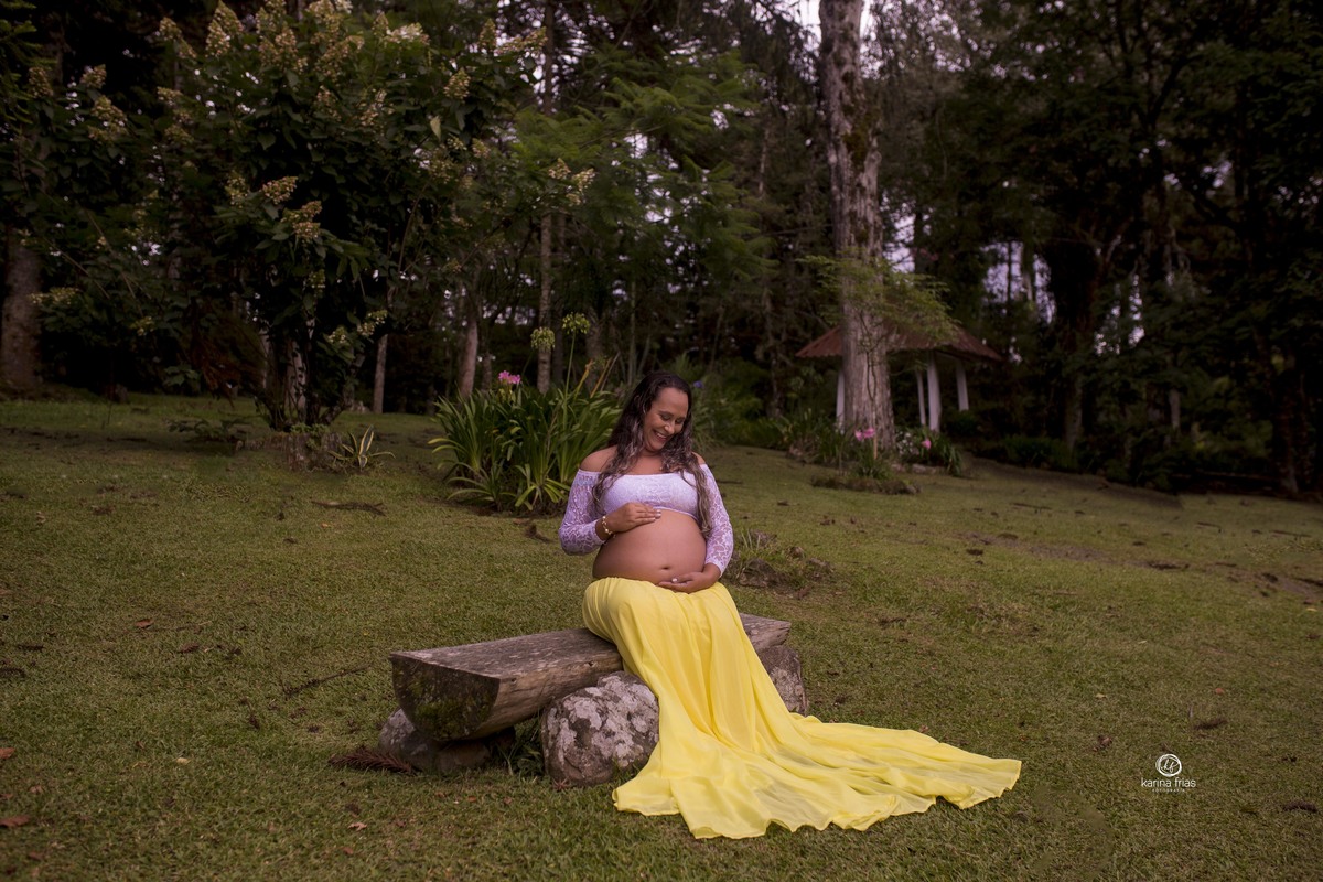 a gestante olha para a barriga no ensaio de gestante