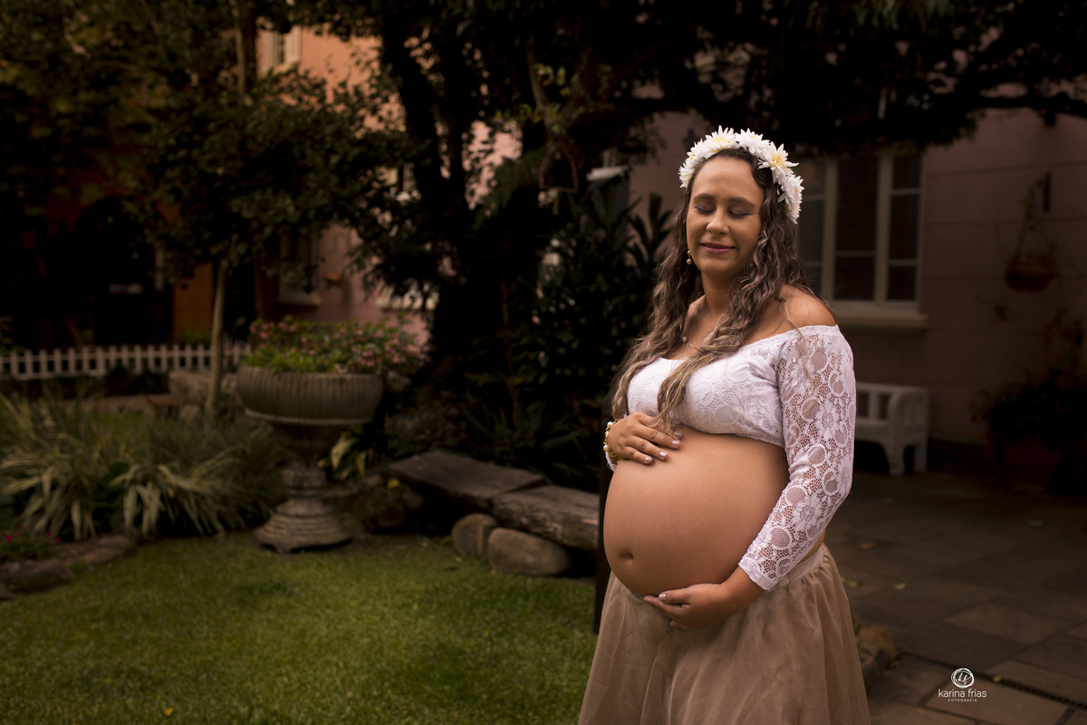 no ensaio externo de gestante a modelo olha para a a barriga