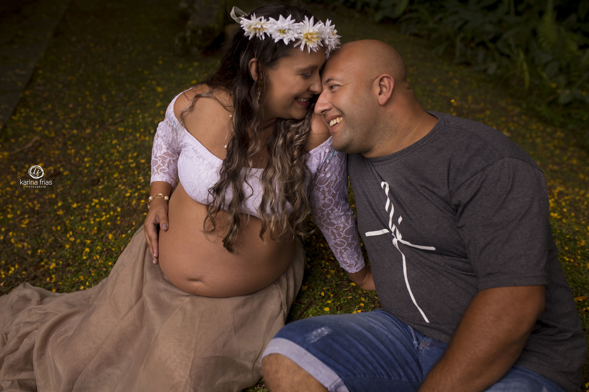 os pais sorriem no ensaio externo de gestante